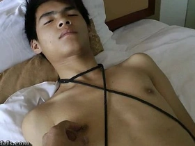 Gay Asian boys in bondage perform a handjob