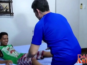 Elderly woman tempted by young Asian Marcon in kitchen